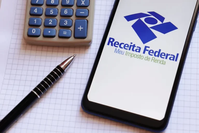 celular ao lado de calculadora com logo da Receita Federal e do app "Meu Imposto de Renda"
