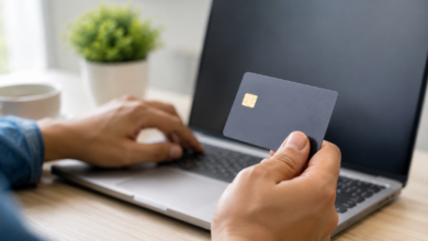 Pessoa usando um cartão de crédito com cashback no notebook